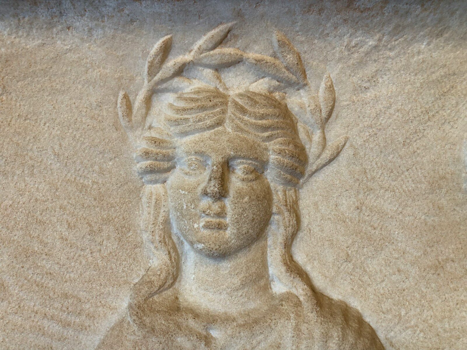Carved relief of a woman wearing a laurel wreath.